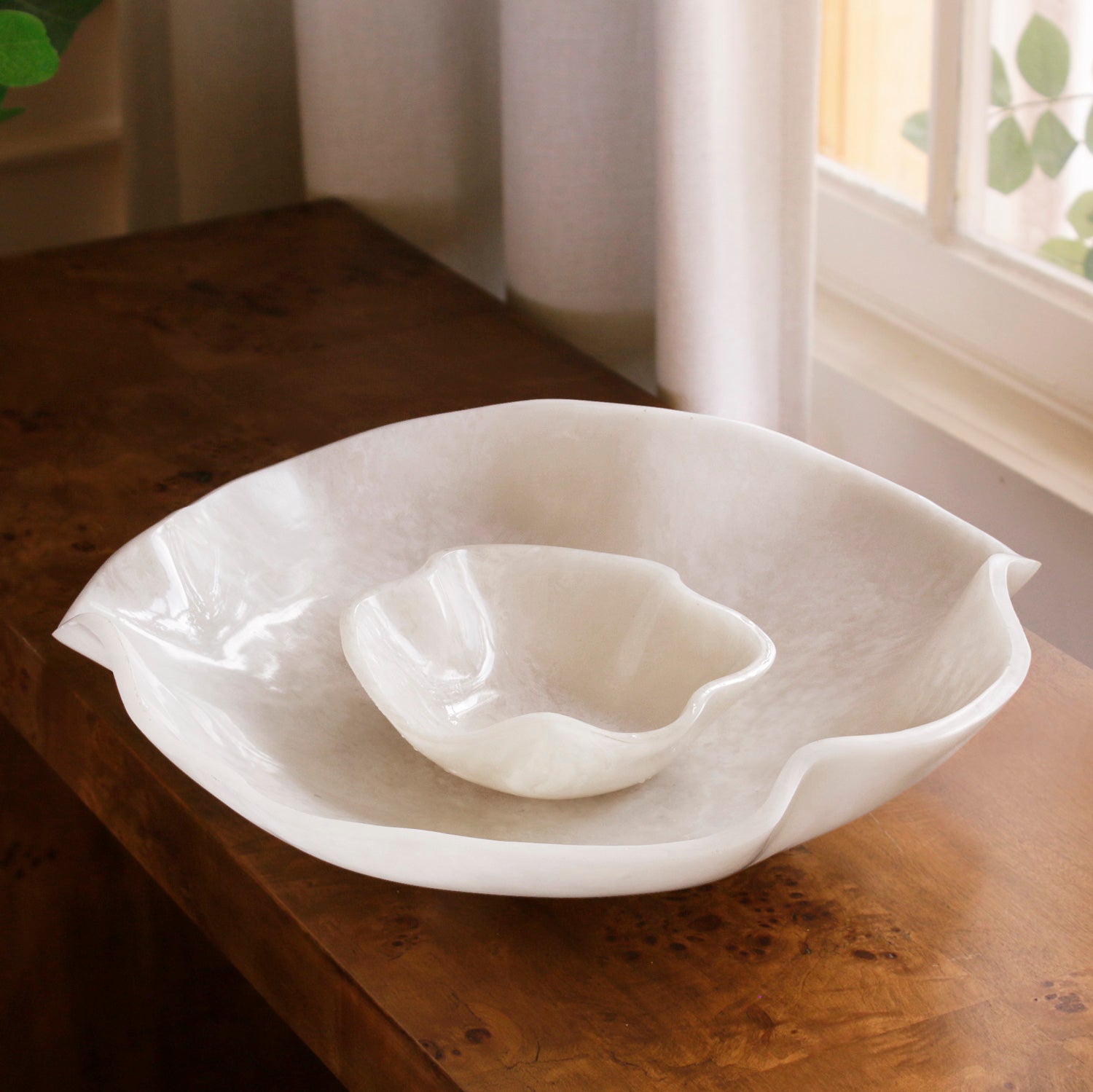 White resin bowl on a wooden surface with a soft, natural light background