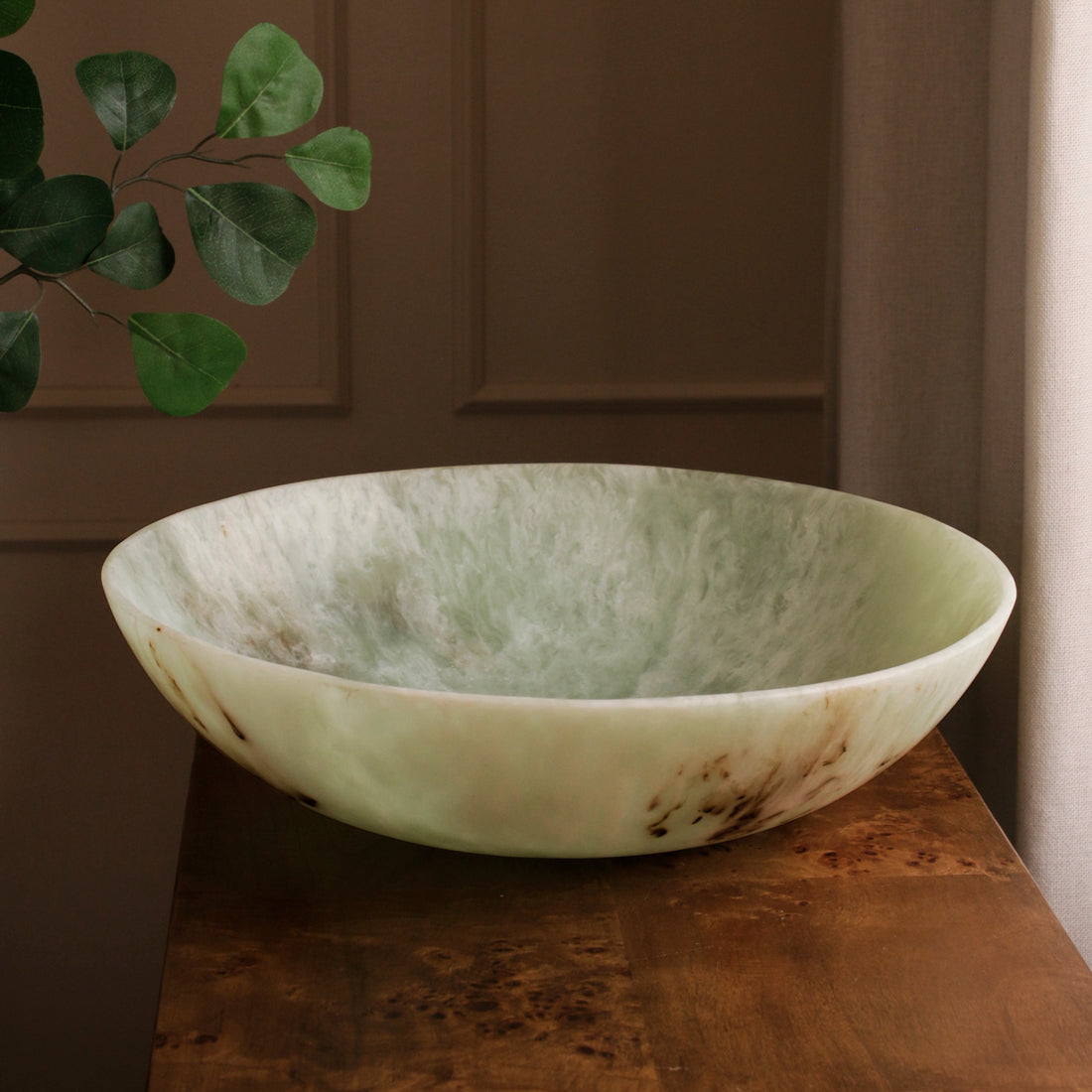 Green marble bowl on a wooden surface with a blurred background