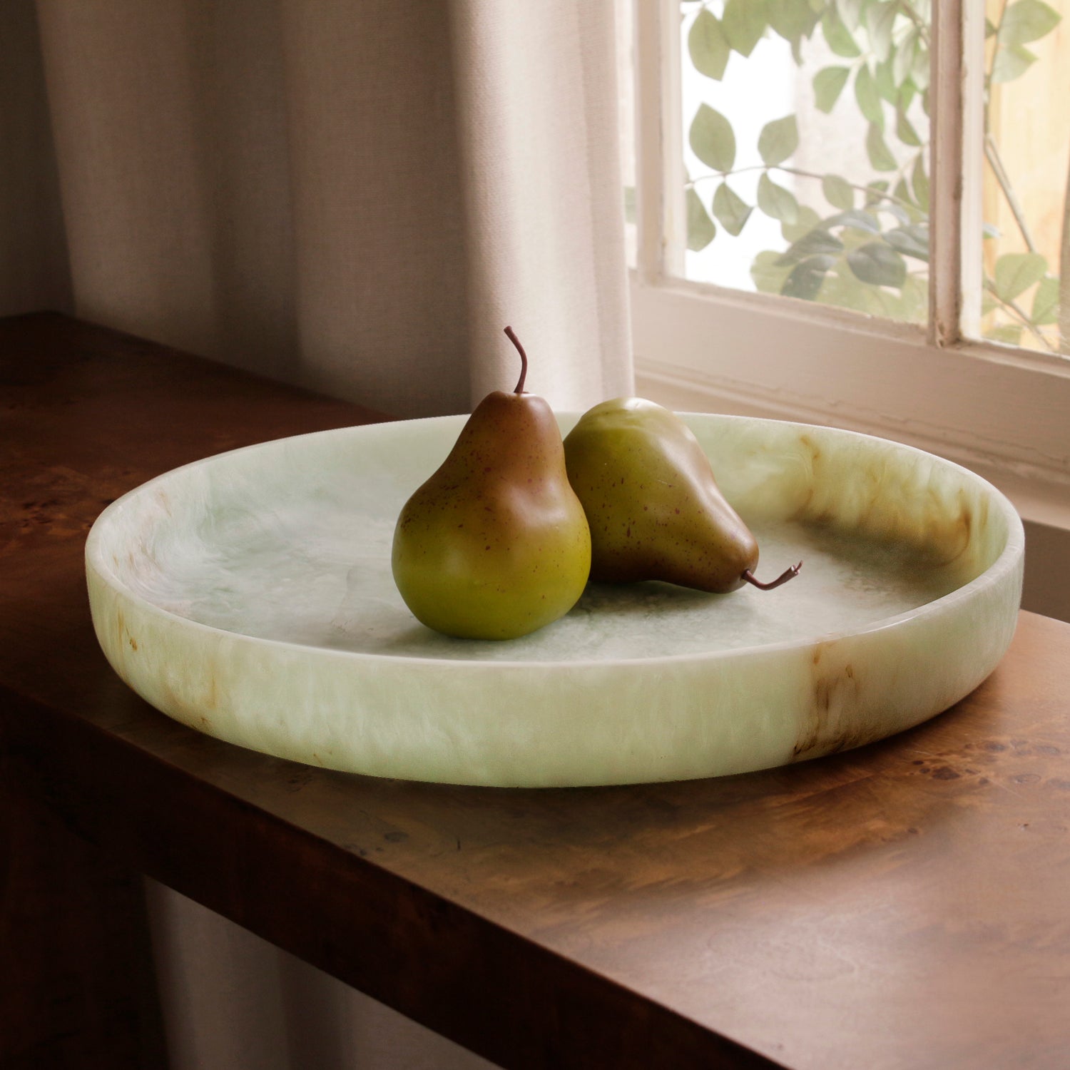 Two pears on a marble pattern resin tray with a window in the background