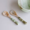 Two Two Salad Servers with jade swirl marble pattern resin handles on a light background