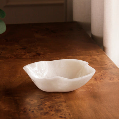 White resin bowl on a wooden surface