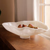 White resin bowl with fruits on a wooden surface