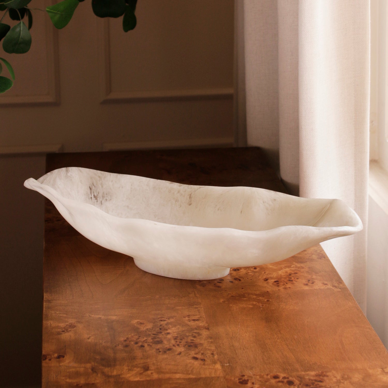 White resin bowl on a wooden surface with a neutral background