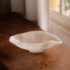White resin bowl on a wooden surface with natural light