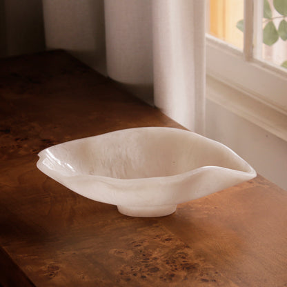 White resin bowl on a wooden surface with natural light