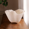 White alabaster bowl on a wooden surface with a neutral background