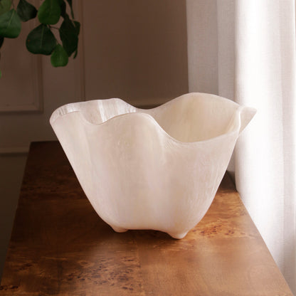 White alabaster bowl on a wooden surface with a neutral background