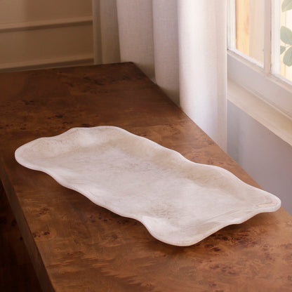 White alabaster resin tray on a wooden surface near a window